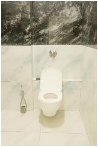 a bathroom with a white toilet in a room at Hotel Premium IN Tulsi GH Near Shri Mahakaleshwar Jyotirlinga Temple - Fully Air Air Conditioning Rooms - Prime Location in Ujjain