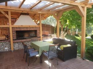 een houten pergola met een tafel en een bank bij Luxury Family Villa on Neretva - Private Pool - Vila Kuća Mira in Konjic