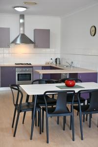 a kitchen with a table and chairs in a kitchen at Griffith Prestige Apartment in Griffith +18 photos