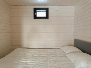 Una cama en una habitación pequeña con ventana. en Luokki 2, en Syöte
