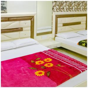 a bedroom with two beds and a red rug at Hotel Premium IN Tulsi GH Near Shri Mahakaleshwar Jyotirlinga Temple - Fully Air Air Conditioning Rooms - Prime Location in Ujjain +3 photos