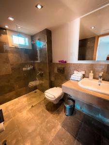 a bathroom with a toilet and a sink and a shower at Nayah Stays, Amazing villa with private pool & 5 master suites in Hurghada