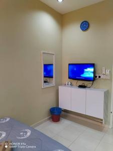 a living room with a tv and a white cabinet at NZ Villa Roomstay in Kangar +19 photos