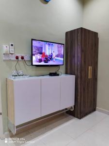 a flat screen tv sitting on top of a white cabinet at NZ Villa Roomstay in Kangar