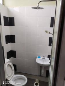 a bathroom with a white toilet and a sink at NZ Villa Roomstay in Kangar