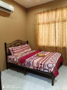 a bedroom with a bed and a window at NZ Villa Roomstay in Kangar
