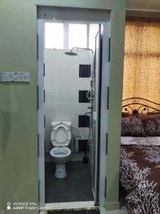 a bathroom with a toilet in a room at NZ Villa Roomstay in Kangar