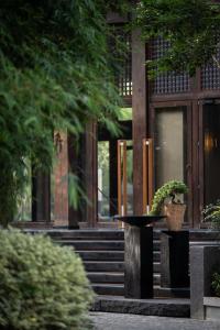 a building with a potted plant in front of it at XIN HOTEL in Hangzhou