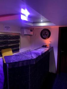 a kitchen with purple lighting and a counter top at 111Suites&Lounge in Aba