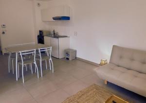 Una sala de estar con un sofá y una mesa y una cocina. en Le Cocon Centre ville - Cosy - Proche station service, en Ville-la-Grand