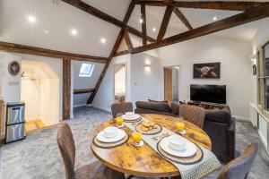 Una sala de estar con una mesa y sillas de madera. en Grade II Listed Top Floor Flat in Central Banbury - Pass the Keys, en Banbury