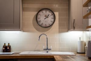 un reloj en una pared sobre un fregadero de cocina en Grade II Listed Top Floor Flat in Central Banbury - Pass the Keys, en Banbury 33 fotos más