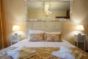 V_Paradise في إيراكليتسا: غرفة نوم بها سرير عليه منشفتان