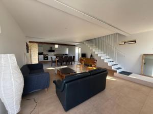 a living room with two couches and a staircase at Le Pressoir, maison au calme, jardin, terrasse, 3 chambres, 2 sdb, 2 WC, proche Bayeux et Arromanches au coeur des plages du débarquement in Longues-sur-Mer
