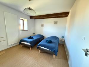 two beds in a room with blue sheets at Le Pressoir, maison au calme, jardin, terrasse, 3 chambres, 2 sdb, 2 WC, proche Bayeux et Arromanches au coeur des plages du débarquement in Longues-sur-Mer