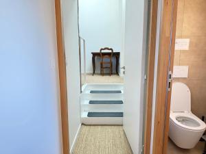 a bathroom with a toilet and a table with a chair at Le Pressoir, maison au calme, jardin, terrasse, 3 chambres, 2 sdb, 2 WC, proche Bayeux et Arromanches au coeur des plages du débarquement in Longues-sur-Mer +25 photos
