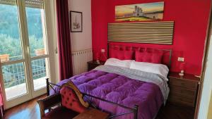 a bedroom with a purple bed and a window at Agriturismo La Terrazza in Valfabbrica