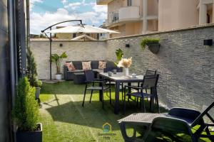 a patio with a table and chairs and an umbrella at Coho House Fiumicino in Fiumicino