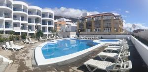 a swimming pool with lounge chairs and a hotel at BEACHITO Puerto Naos in Puerto Naos