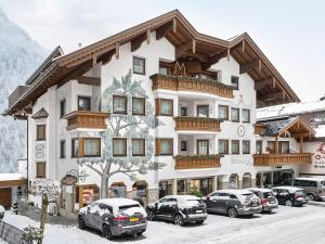 a large building with cars parked in front of it at Hotel Magdalena Mayrhofen in Mayrhofen