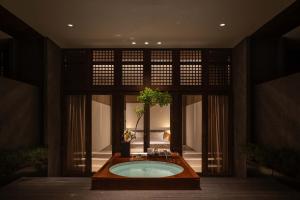a bathroom with a tub with a plant in it at XIN HOTEL in Hangzhou