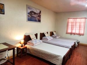 锡朗米妮旅馆的一间卧室，有两张床、一张桌子和一扇窗户