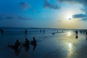 Serenova Resort by ILIF Hotels في مورود: مجموعة من الناس يجلسون على الشاطئ عند غروب الشمس