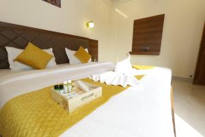 Serenova Resort by ILIF Hotels في مورود: غرفة نوم بسرير ابيض عليها صندوق خشبي