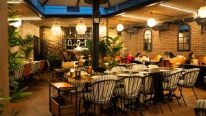 a restaurant with tables and chairs and people sitting at tables at BANDIRMA PALAS OTEL in Bandırma