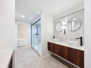 une salle de bain blanche avec deux lavabos et un miroir dans l'établissement Douce escapade - Baignoire balnéo, à Brest