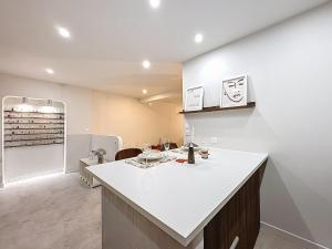 - une cuisine avec une grande île blanche dans une chambre dans l'établissement Douce escapade - Baignoire balnéo, à Brest