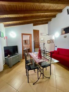 un soggiorno con un tavolo e un divano rosso di SinyHouse a Terrasini