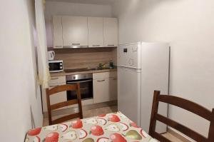 a kitchen with a table and a white refrigerator at Apartments Dara in Umag +36 photos