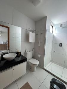 a bathroom with a toilet and a sink and a shower at Flat Resort ILOA in Barra de São Miguel