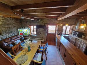 Una cocina y una sala de estar con mesa y sillas. en Casa Laudina y Armando, en Brañella