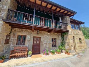 una casa de piedra con balcón y puerta de madera en Casa Laudina y Armando, en Brañella