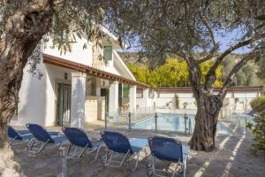 a group of chairs sitting next to a swimming pool at Rhodia Villa in Ayios Isidhoros