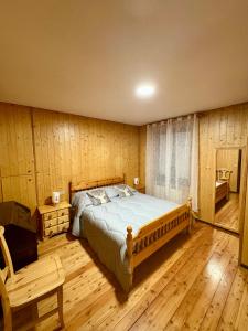 een slaapkamer met een bed en een houten vloer bij Altea Retreat in Ponte di Legno