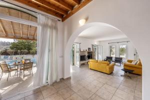 a living room with a yellow couch and a table at Rhodia Villa in Ayios Isidhoros