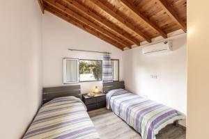 two beds in a room with a window at Rhodia Villa in Ayios Isidhoros +50 photos