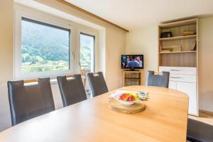 Un comedor con una mesa con un bol de fruta encima. en Haus Tramontana, en Gaschurn