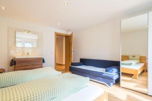 Un dormitorio con dos camas y un sofá azul. en Haus Tramontana, en Gaschurn