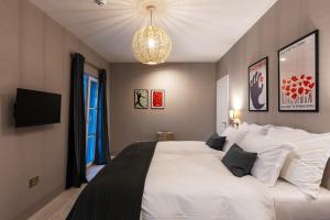 um quarto com uma grande cama branca e um lustre em Villa RudaVista em Brsečine