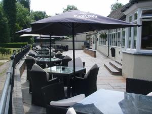 a row of tables and chairs under an umbrella at Half Moon Jackfield in Bridgnorth