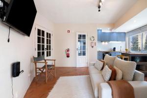 a living room with a couch and a kitchen at Apartamento Davasa in Armação de Pêra