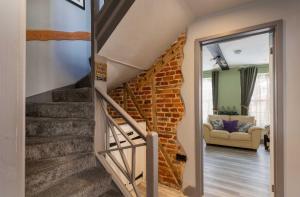 a staircase in a house with a brick wall at Charming Jersey Cottage with parking 8 Guests in Cowes