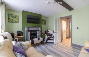 a living room with a couch and a fireplace at Charming Jersey Cottage with parking 8 Guests in Cowes +38 photos