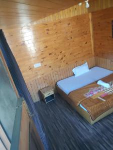 a bedroom with a bed in a wooden cabin at Holy apple in Nagar