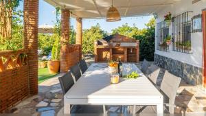 a white table and chairs on a patio at Villa Rocío, Acogedora villa con piscina de agua salada en Vélez Málaga in Almayate Alto