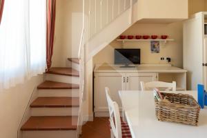 una cucina e una scala con un tavolo e sedie bianchi di Homiday - Villa Rosella a Roseto degli Abruzzi